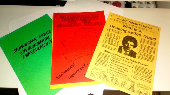 Three brochures on housing and environment, one red, one yellow and one green